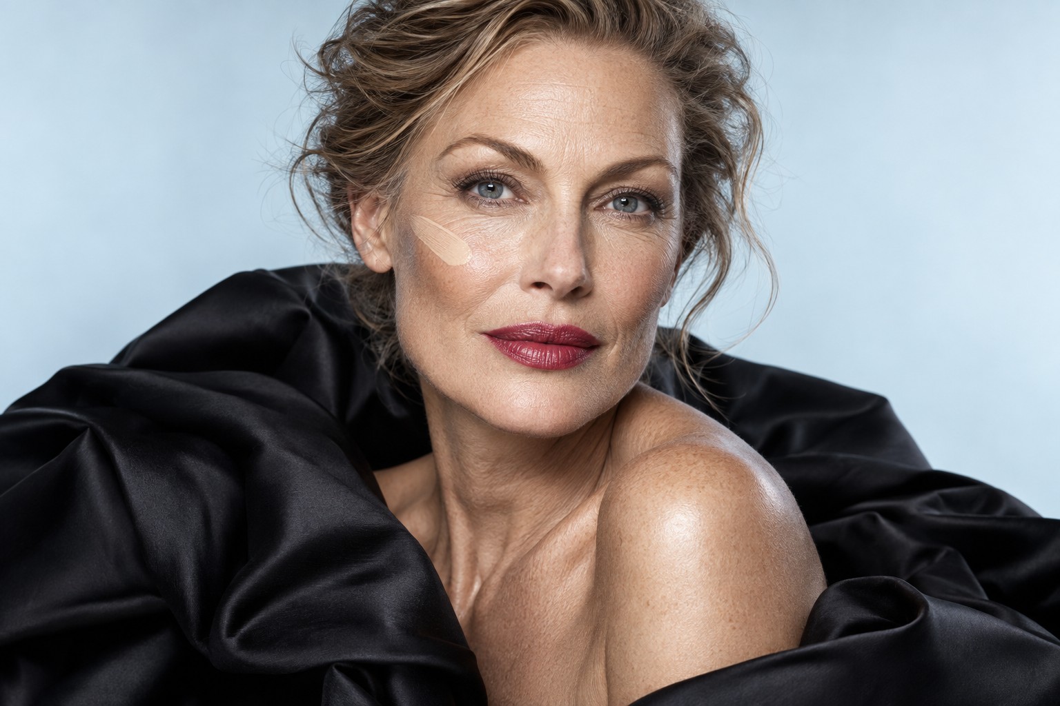 Editorial portrait with a creamy makeup swatch on the cheek